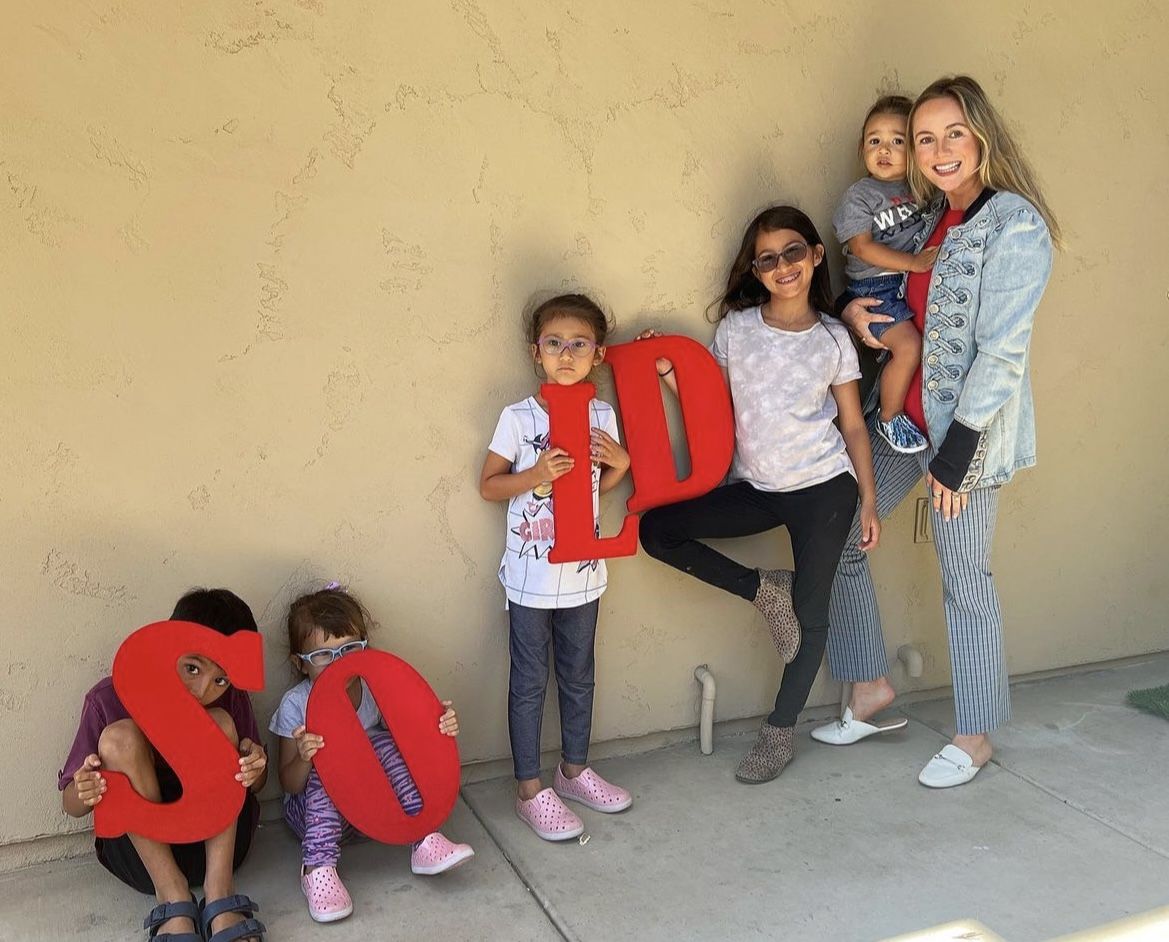 woman and kids holding sold sign